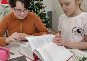 Nikola i Nikola szukają w słowniku informacji o kolędach i pastorałkach