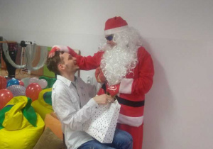 Chłopiec odbiera prezent od Mikołaja