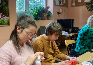 Wiktoria i Dominik sklejają elementy ozdób