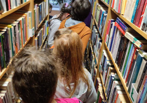 Pani bibliotekarka oprowadza dzieci po bibliotece