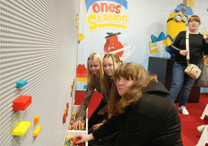 Trzy uczennice wybierają z pojemników klocki lego