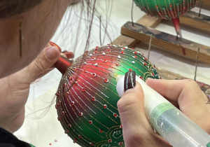 Dekorowanie bombki, która niebawem ozdobi świąteczne drzewko.